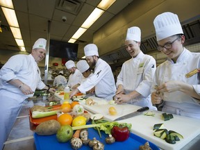 Instructor John Lewis, left, speaks with culinary students as they prepare dishes during a class at Vancouver Community College's downtown campus.