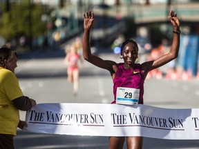 Risper Gesabwa of Kenya crosses the finish line to win the women’s division at the annual Vancouver Sun Run in Vancouver on April 19, 2015.