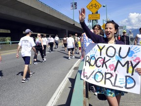 Aden Kotter shouts out encouragement to the runners while she waits for her mom along the route of the 26th Annual Vancouver Sun Run in downtown Vancouver, May, 09, 2010.