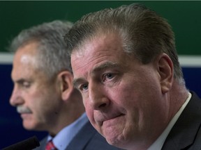 Vancouver Canucks general manager Jim Benning (right, with head coach Willie Desjardins) pauses for a moment during Tuesday’s news conference at Rogers Arena.