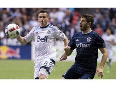 Vancouver Whitecaps FC defender Fraser Aird and Sporting Kansas City midfielder Connor Hallisey (22) fight for control of the ball during the first half of MLS soccer action in Vancouver, B.C. Wednesday, April 27, 2015.