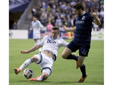 Vancouver Whitecaps FC defender Fraser Aird fights for control of the ball with Sporting Kansas City midfielder Connor Hallisey (22) during the first half of MLS soccer action in Vancouver, B.C. Wednesday, April 27, 2015.