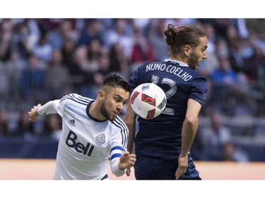 Vancouver Whitecaps midfielder Pedro Morales (77) fights for control of the ball with Sporting Kansas City defender Nuno Coelho (12) during the first half of MLS soccer action in Vancouver, B.C. Wednesday, April 27, 2015.
