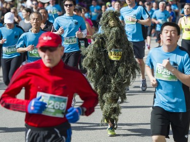 A runner runs in a ghillie suit in the 2016 Vancouver Sun Run .