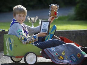 Ethan Hippel, who has collected all 63 scout badges, with the 'hedgehog' he made for Syrian refugee children and the soap-box car he made for his carpentry badge.