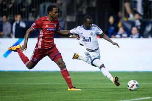 Vancouver Whitecaps' Kekuta Manneh, right, moves the ball past FC Dallas' Atiba Harris during the second half. 