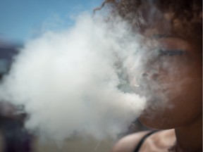 A woman exhales after taking a hit from a bong during the annual 4/20 cannabis culture celebration at Sunset Beach in Vancouver, B.C., on Wednesday April 20, 2016.