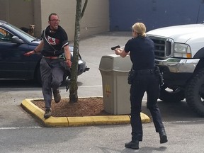 Amateur photographer Bill Whatcott took these cellphone photos of a Vancouver Police Officer shooting a knife-wielding man in the leg in the McDonald's parking lot (3444 E Hastings Street) on May 24, 2016.  [PNG Merlin Archive]