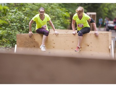 A couple of women climb over a wall while taking part in the Woman2Warrior event at Swangard Stadium and Central Park in Burnaby, BC, May, 15, 2016. Funds raised through this all-women charity obstacle adventure race will benefit the BC Lions Society and Easter Seals camps for children with disabilities.