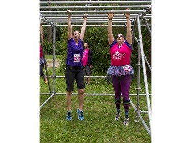 A couple of women find a clever way of making their way through the monkey bars obstacle while taking part in the Woman2Warrior event at Swangard Stadium and Central Park in Burnaby, BC, May, 15, 2016. Funds raised through this all-women charity obstacle adventure race will benefit the BC Lions Society and Easter Seals camps for children with disabilities.