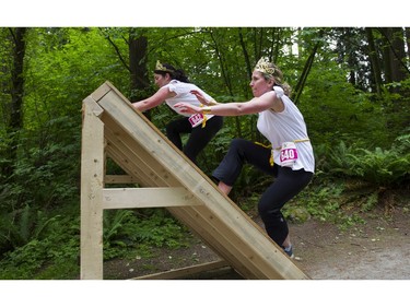 A couple of women take on a giant ramp obstacle while taking part in the Woman2Warrior event at Swangard Stadium and Central Park in Burnaby, BC, May, 15, 2016. Funds raised through this all-women charity obstacle adventure race will benefit the BC Lions Society and Easter Seals camps for children with disabilities.