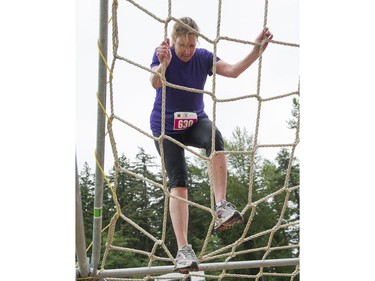 A participant climbs up a net on the final obstacle while taking part in the Woman2Warrior event at Swangard Stadium and Central Park in Burnaby, BC, May, 15, 2016. Funds raised through this all-women charity obstacle adventure race will benefit the BC Lions Society and Easter Seals camps for children with disabilities.