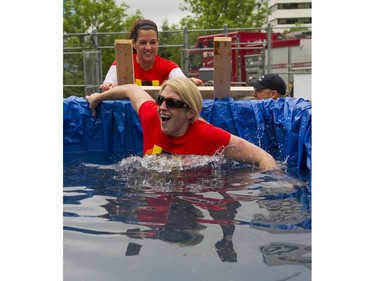 A participant reacts after jumping into the ice bath while taking part in the Woman2Warrior event at Swangard Stadium and Central Park in Burnaby, BC, May, 15, 2016. Funds raised through this all-women charity obstacle adventure race will benefit the BC Lions Society and Easter Seals camps for children with disabilities.