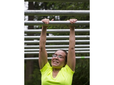 A woman battles on while making her way through the monkey bars obstacle while taking part in the Woman2Warrior event at Swangard Stadium and Central Park in Burnaby, BC, May, 15, 2016. Funds raised through this all-women charity obstacle adventure race will benefit the BC Lions Society and Easter Seals camps for children with disabilities.