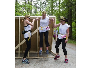 A woman gets some help from her teammates while jumping off a wall obstacle while taking part in the Woman2Warrior event at Swangard Stadium and Central Park in Burnaby, BC, May, 15, 2016. Funds raised through this all-women charity obstacle adventure race will benefit the BC Lions Society and Easter Seals camps for children with disabilities.