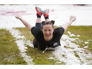 A woman is all smiles while sliding down the slip and slide obstacle while taking part in the Woman2Warrior event at Swangard Stadium and Central Park in Burnaby, BC, May, 15, 2016. Funds raised through this all-women charity obstacle adventure race will benefit the BC Lions Society and Easter Seals camps for children with disabilities.