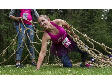 A woman reacts after crawling out from under a giant net while taking part in the Woman2Warrior event at Swangard Stadium and Central Park in Burnaby, BC, May, 15, 2016. Funds raised through this all-women charity obstacle adventure race will benefit the BC Lions Society and Easter Seals camps for children with disabilities.