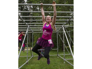 A woman swings her way through the monkey bars obstacle while taking part in the Woman2Warrior event at Swangard Stadium and Central Park in Burnaby, BC, May, 15, 2016. Funds raised through this all-women charity obstacle adventure race will benefit the BC Lions Society and Easter Seals camps for children with disabilities.