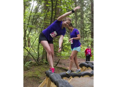A woman tries to stay on the balance beam obstacle while taking part in the Woman2Warrior event at Swangard Stadium and Central Park in Burnaby, BC, May, 15, 2016. Funds raised through this all-women charity obstacle adventure race will benefit the BC Lions Society and Easter Seals camps for children with disabilities.