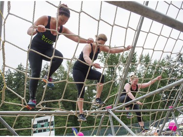 Participants climb up a net on the final obstacle while taking part in the Woman2Warrior event at Swangard Stadium and Central Park in Burnaby, BC, May, 15, 2016. Funds raised through this all-women charity obstacle adventure race will benefit the BC Lions Society and Easter Seals camps for children with disabilities.