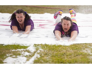 Participants slide down the slip and slide obstacle while taking part in the Woman2Warrior event at Swangard Stadium and Central Park in Burnaby, BC, May, 15, 2016. Funds raised through this all-women charity obstacle adventure race will benefit the BC Lions Society and Easter Seals camps for children with disabilities.