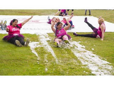 Participants slide through the slip and slide obstacle while taking part in the Woman2Warrior event at Swangard Stadium and Central Park in Burnaby, BC, May, 15, 2016. Funds raised through this all-women charity obstacle adventure race will benefit the BC Lions Society and Easter Seals camps for children with disabilities.