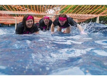 Women crawl through a water obstacle while taking part in the Woman2Warrior event at Swangard Stadium and Central Park in Burnaby, BC, May, 15, 2016. Funds raised through this all-women charity obstacle adventure race will benefit the BC Lions Society and Easter Seals camps for children with disabilities.