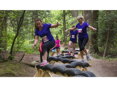 Women make their way over a balance beam obstacle while taking part in the Woman2Warrior event at Swangard Stadium and Central Park in Burnaby, BC, May, 15, 2016. Funds raised through this all-women charity obstacle adventure race will benefit the BC Lions Society and Easter Seals camps for children with disabilities.