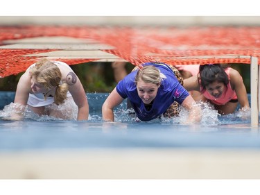 Women tackle the water obstacle while taking part in the Woman2Warrior event at Swangard Stadium and Central Park in Burnaby, BC, May, 15, 2016. Funds raised through this all-women charity obstacle adventure race will benefit the BC Lions Society and Easter Seals camps for children with disabilities.