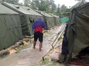 A man walks between tents at Australia's regional processing centre on Manus Island in Papua New Guinea. Papua New Guinea on April 27, 2016 said a controversial asylum-seeker camp on Manus island will close, piling pressure on Australia's border protection policy.