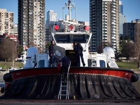 Members of the Canadian Coast Guard stand on a hovercraft docked outside the Kitsilano Coast Guard facility in Vancouver, B.C., on December 16, 2015.