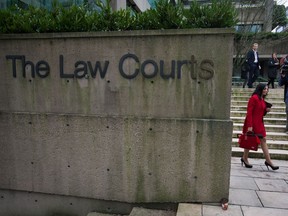 Eileen Mohan, centre, leaves B.C. Supreme Court in Vancouver, B.C., on Friday December 12, 2014 during a break in the sentencing for Cody Haevischer and Matthew Johnston, who were both found guilty in October of six counts of first-degree murder in the 2007 gang slayings of six people. Mohan's 22-year-old son Chris was killed along with five other people at a Surrey, B.C., high rise in 2007.
