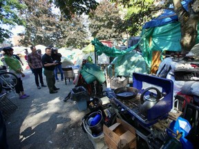 Inspector Bob Cooper, third from left in black shirt, of the Office of the Fire Commissioner, inspects the tent city on the Victoria courthouse lawn on Wednesday, May 25, 2016.