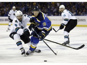 St. Louis Blues defenseman Jay Bouwmeester (19) tries to control the puck against San Jose Sharks right wing Dainius Zubrus (9) during the third period in Game 1 of the NHL hockey Stanley Cup Western Conference finals, Sunday, May 15, 2016, in St. Louis.