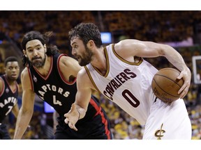 FILE - In this Wednesday, May 25, 2016, file photo, Cleveland Cavaliers' Kevin Love (0) drives on Toronto Raptors' Luis Scola (4), from Argentina, during the second half of Game 5 of the NBA basketball Eastern Conference finals in Cleveland. Dropping his first shot in the lane, Love was a different player for the Cavaliers in Game 5. He shook off two horrid games in Toronto by scoring 25 points in Cleveland's blowout, a performance that boosted his confidence and renewed his teammate's trust in him.