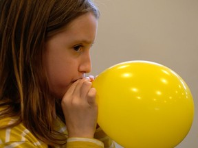 CHI Kids participant blows a balloon