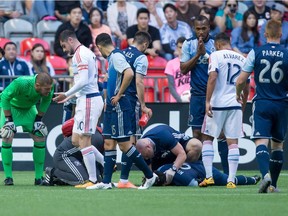Vancouver Whitecaps striker Masato Kudo is sprawled out on the turf, surrounded by medical officials and players, after colliding with Chicago Fire goalkeeper Matt Lampson (in green) during Wednesday’s Major League Soccer game at B.C. Place Stadium. Kudo suffered a broken jaw.