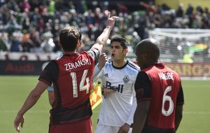 Portland Timbers midfielder Ben Zemanski (14) and Vancouver Whitecaps midfielder Matias Laba, center, exchange words.