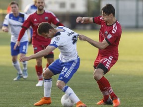 Edmonton's Jake Keegan is grabbed by Ottawa's Fernando Sanfelice during an NASL game between FC Edmonton and the Ottawa Fury in Edmonton on May 11. The Whitecaps take on the Fury in Amway Canadian Championship play on Wednesday. Ian Kucerak files