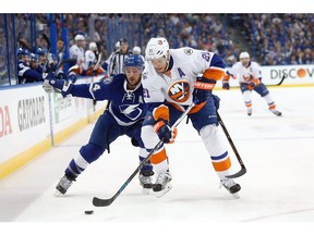 Ryan Callahan, left, of the Tampa Bay Lightning battles against New York Islanders winger Kyle Okposo, a free agent who would be a good addition for the Canucks but may have a hefty price tag.