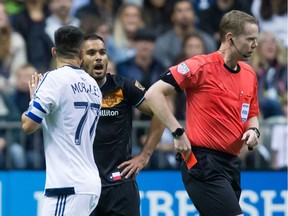 Houston Dynamo's Alex, back, and Vancouver Whitecaps' Pedro Morales, left, react after both received red cards from referee Drew Fischer during the first half of an MLS soccer game in Vancouver, B.C., on Saturday May 28, 2016.