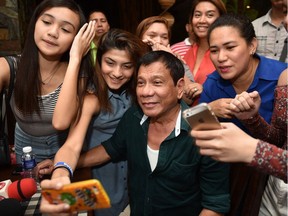 Philippines' President-elect Rodrigo Duterte, poses for selfie pictures with supporters, after speaking to the media for the first time since he claimed victory in the presidential election, at a restaurant in Davao City, on the southern island of Mindanao on May 15. Duterte vowed on May 15 to reintroduce capital punishment and give security forces 'shoot-to-kill' orders.