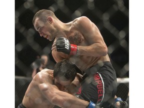 Shane Campbell, top, grapples with Elias Silverio in a UFC lightweight bout last August in Saskatoon.
