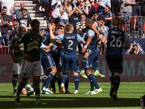 Vancouver Whitecaps' Kendall Waston (4) picks up teammate Christian Bolanos while celebrating Bolanos' goal against the Portland Timbers during second half MLS soccer action in Vancouver, B.C., on Saturday May 7, 2016.