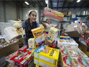 Sikh community members load up large food and supplies for Fort McMurray fire victims, inside the Fruiticana warehouse in Surrey on Sunday.