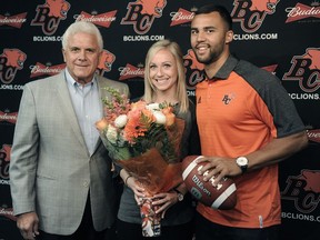 Quarterback Jonathon Jennings, right, smiles after agreeing to a contract extension keeping him in orange through the 2018 season, on Thursday. With him are Wally Buono and fiancee Abigail Misch.