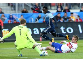 Toronto FC defender Damien Perquis, right, and goalkeeper Clint Irwin defend against Kekuta Manneh on Saturday. The Whitecaps forward scored two goals and set up two others as Vancouver won 4-3.