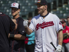 UFC Heavyweight Champ Stipe Miocic, right, a Cleveland native, talks with Cleveland Indians catcher Yan Gomes, left, after taking batting practice with the Indians, before a baseball game against the Cincinnati Reds, in Cleveland, Tuesday. Miicic beat Brazilian Fabricio Werdum Saturday night for the crown.