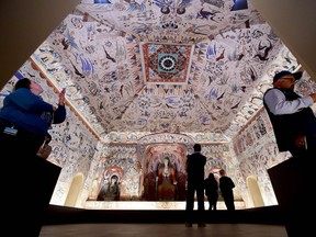 People visit the "Cave Temples of Dunhuang: Buddhist Art on the Silk Road" exhibit at the Getty Center in Los Angeles.