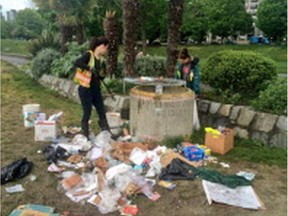 Vancouver park board staff clean up piles of garbage left behind by people at the 420 marijuana gathering at Sunset Beach.